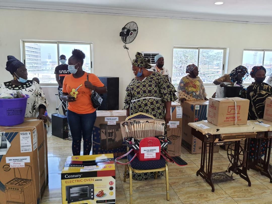 Beneficiaries with sewing machines, ovens, and business equipment